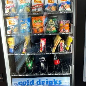 Vending machine filled with chips, chocolate bars, and some cold drinks